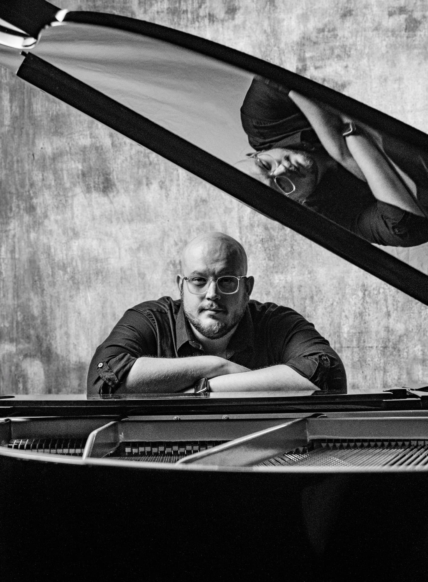 Portrait of composer Jeffrey Carabelos at a grand piano